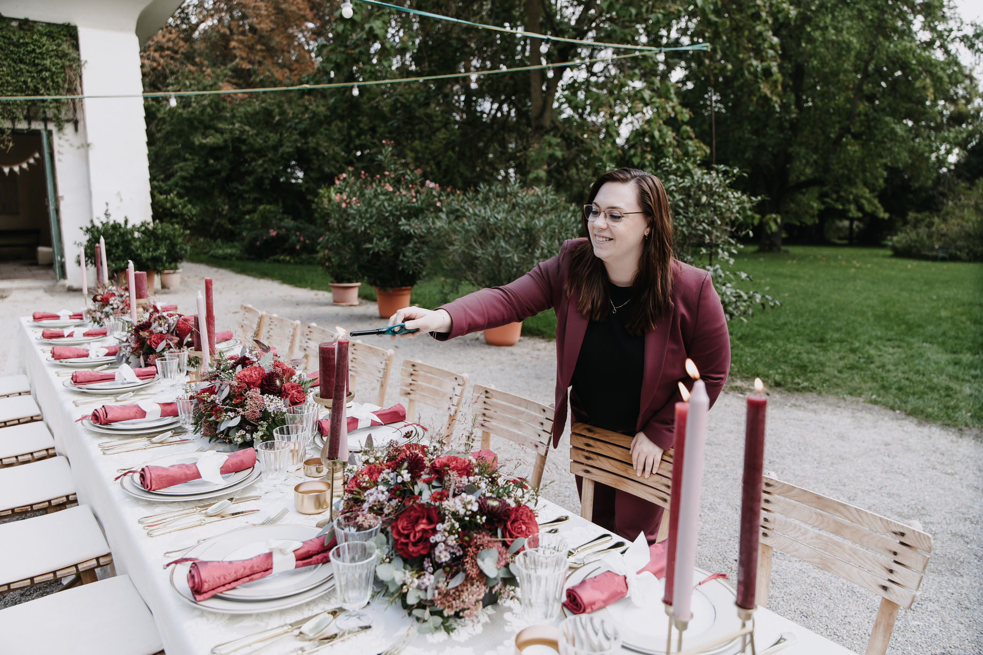 Melanie Hutterer beim dekorieren einer Hochzeitstafel in den Farben burgunder, zartrosa, champagner und gold